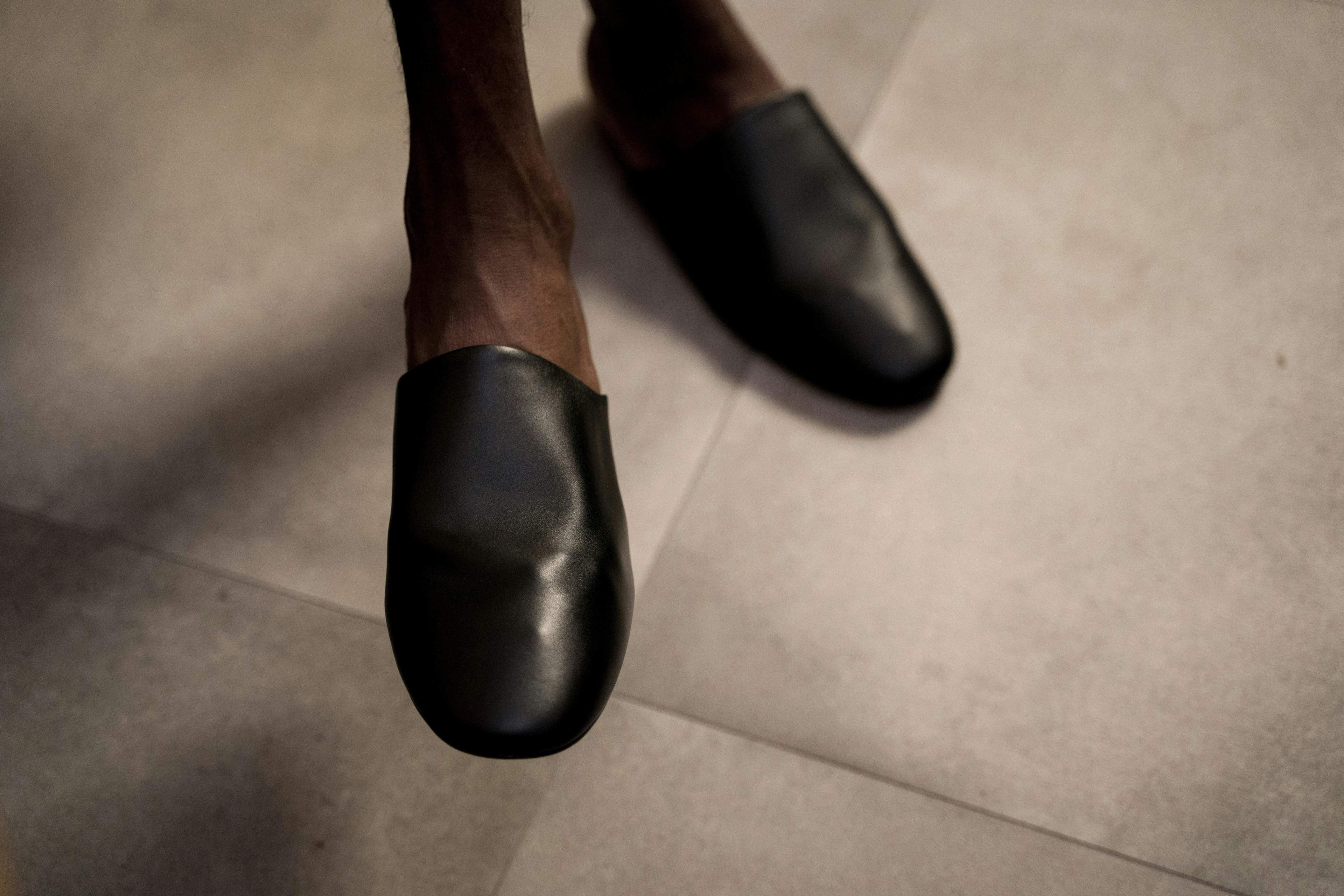 Feet slip into recovery slides on a wooden floor.