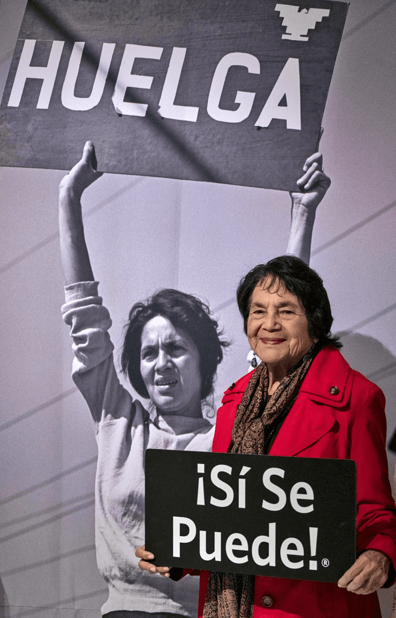 Image of civil rights icon Dolores Huerta standing in the California Museum's installation of "Dolores Huerta: Revolution in the Fields."