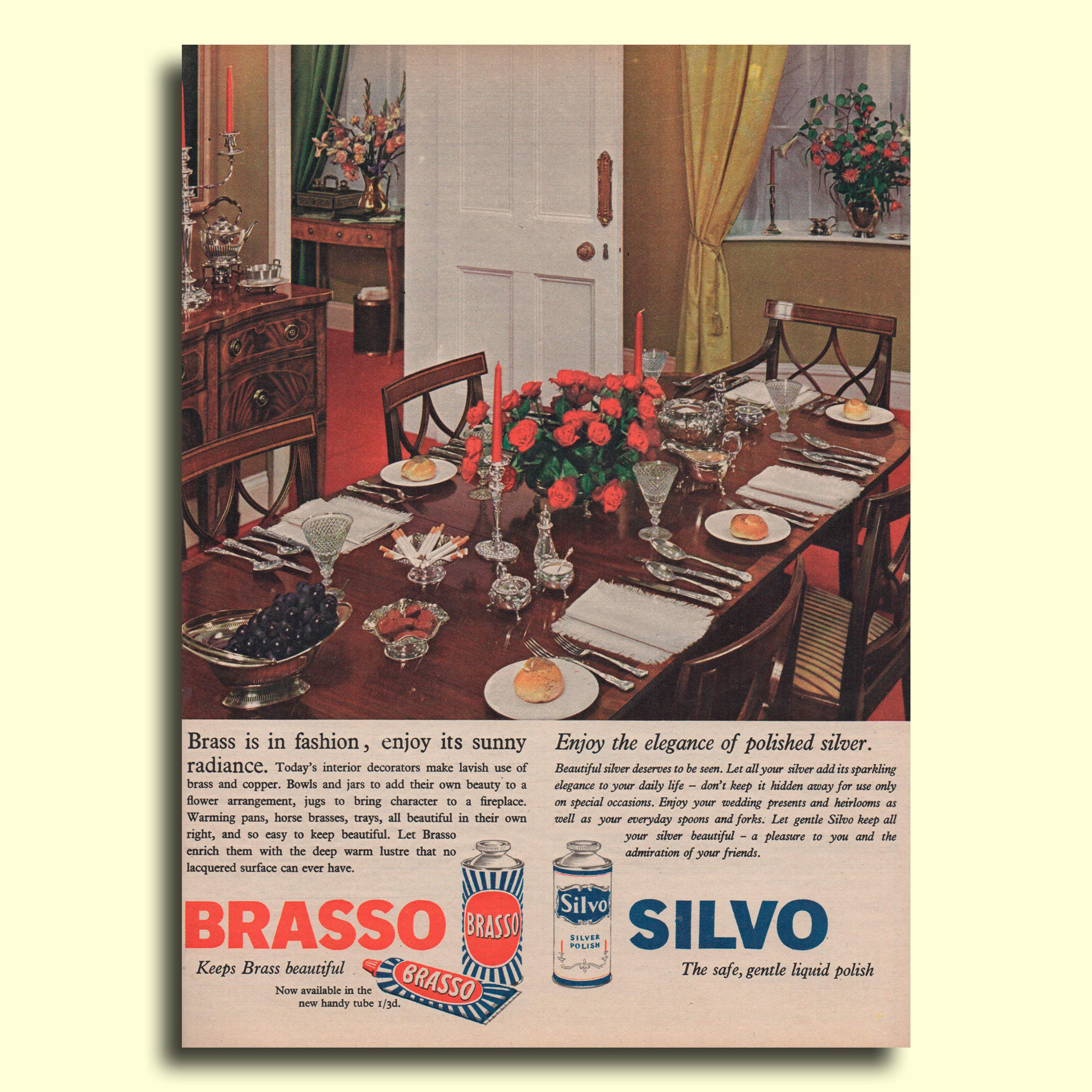 A Brasso and Silvo advert 1962. Colour photograph of a dinner table setting with silver service, candelabra, cut glass and red roses. 