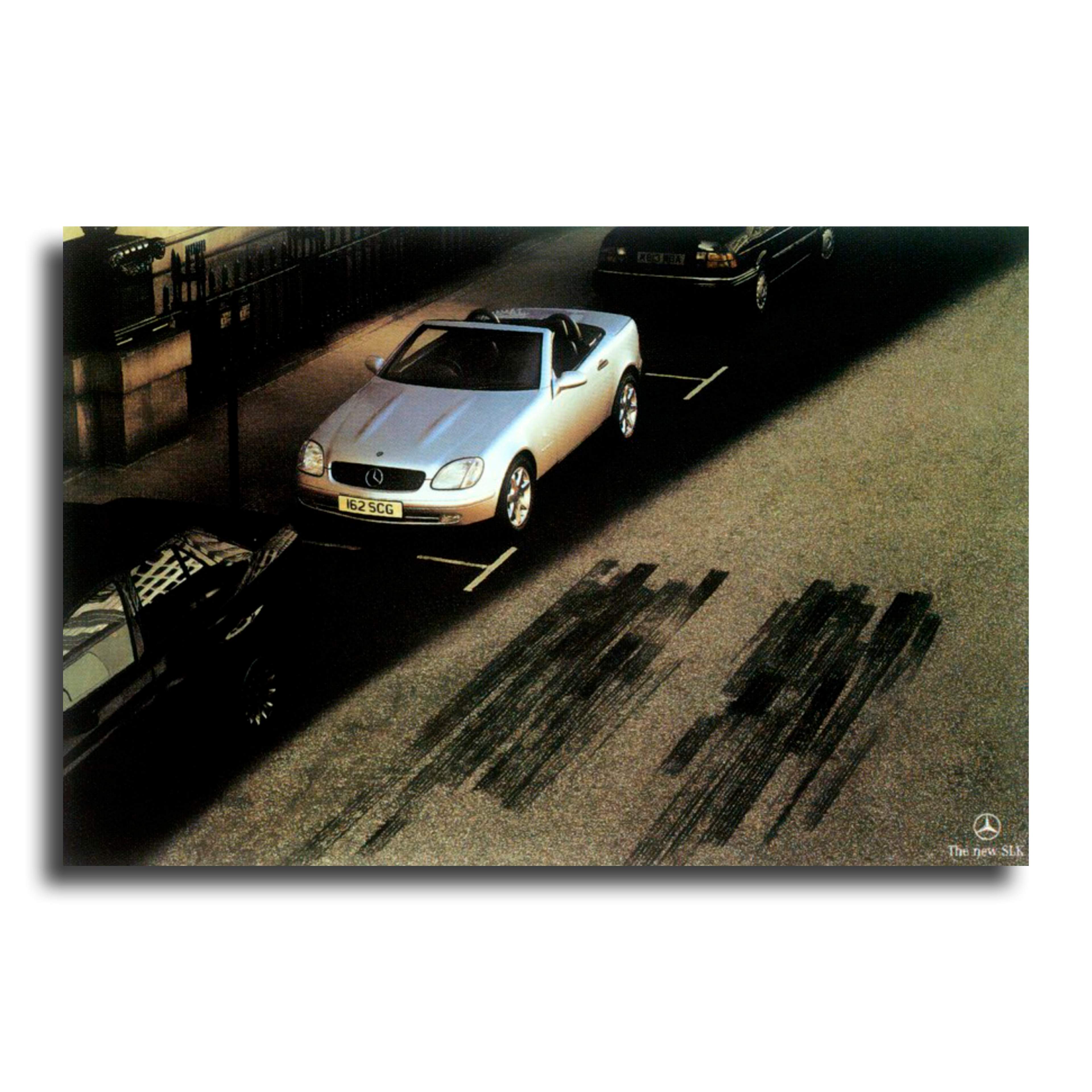Photograph of a silver Mercedes Benz SLK with skid marks on the road. 
