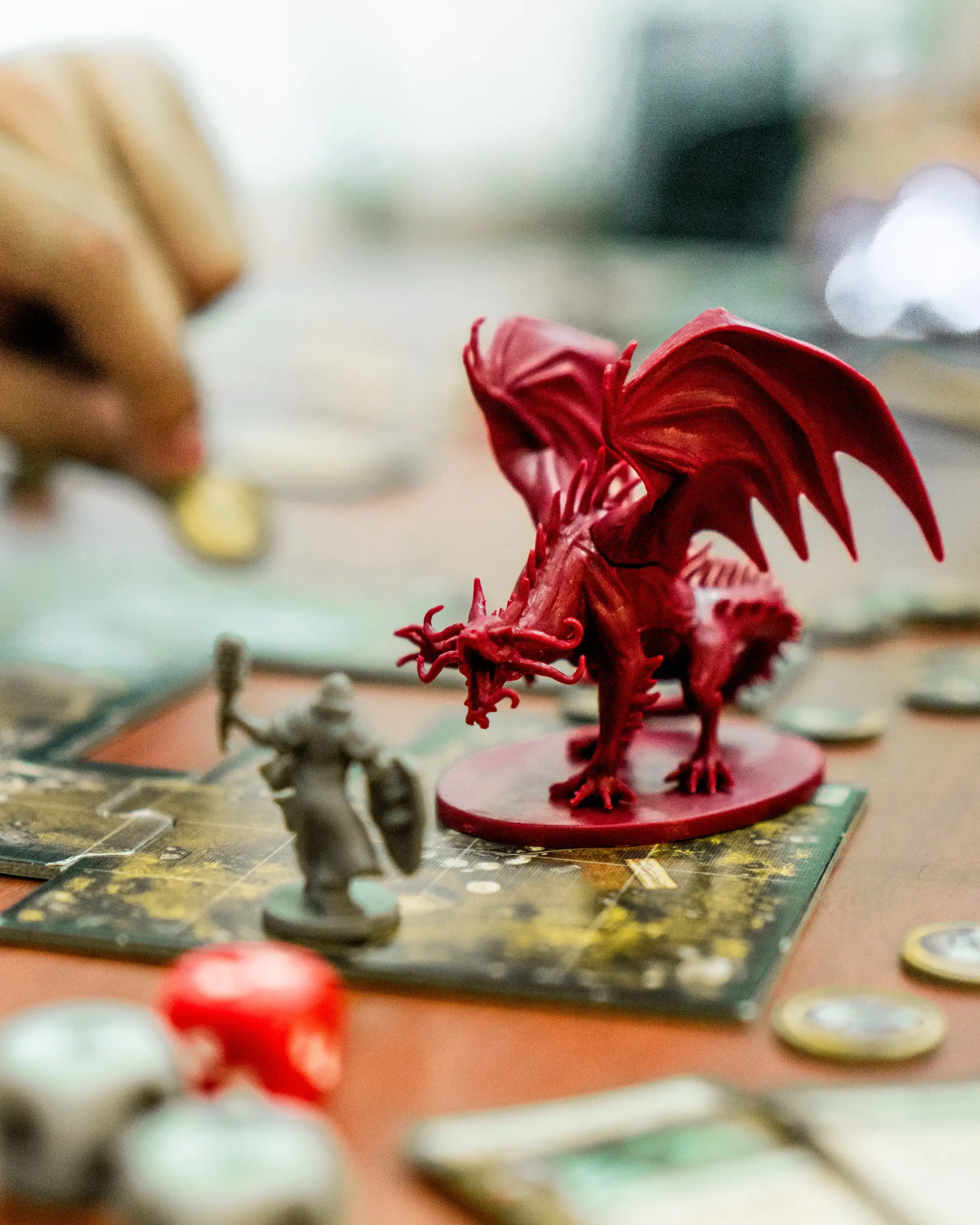 A close up of a red dragon figure on a board game surface.