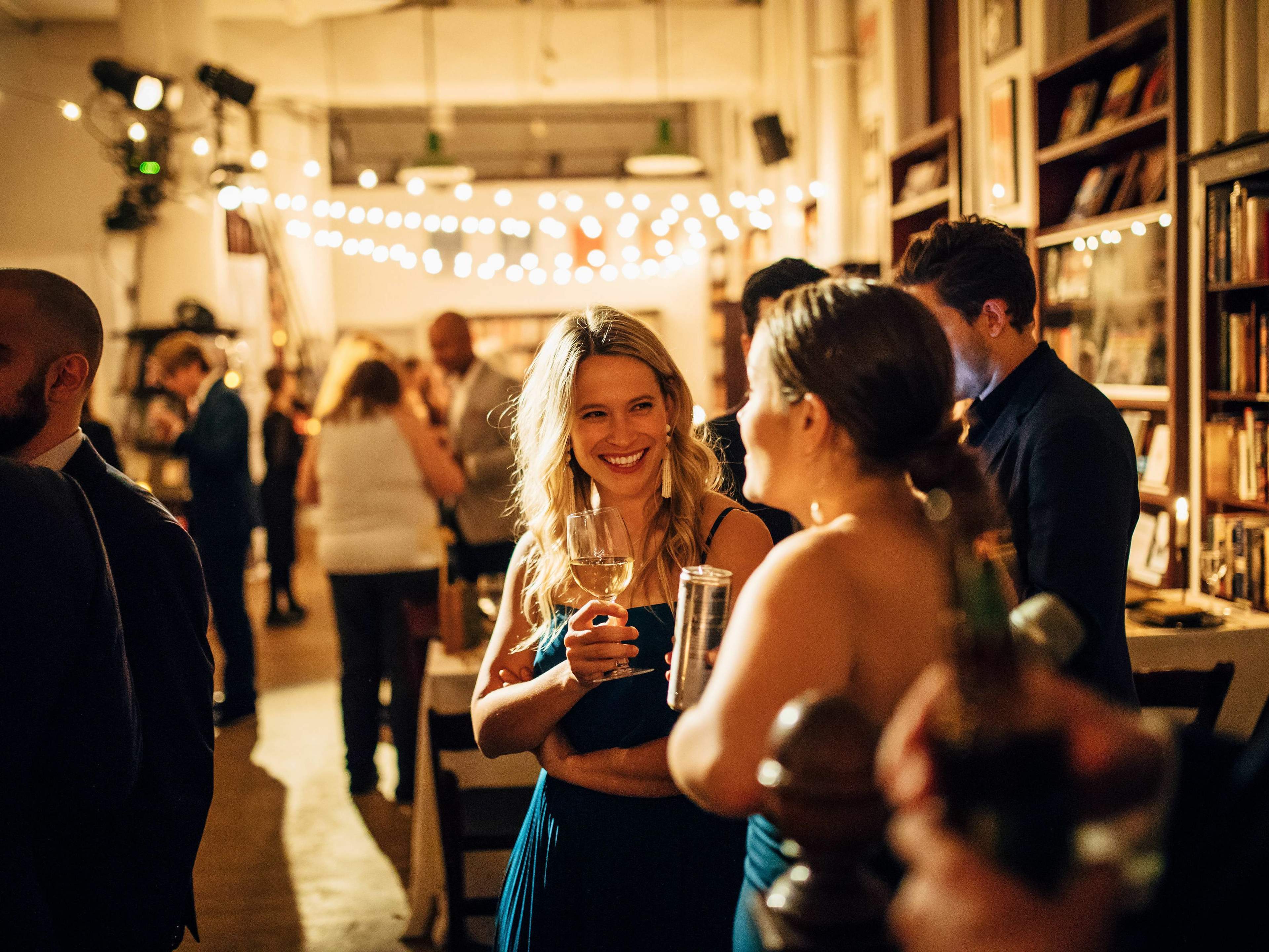 People enjoying cocktails at Housing Works Bookstore—the venue for Understood's annual winter party.