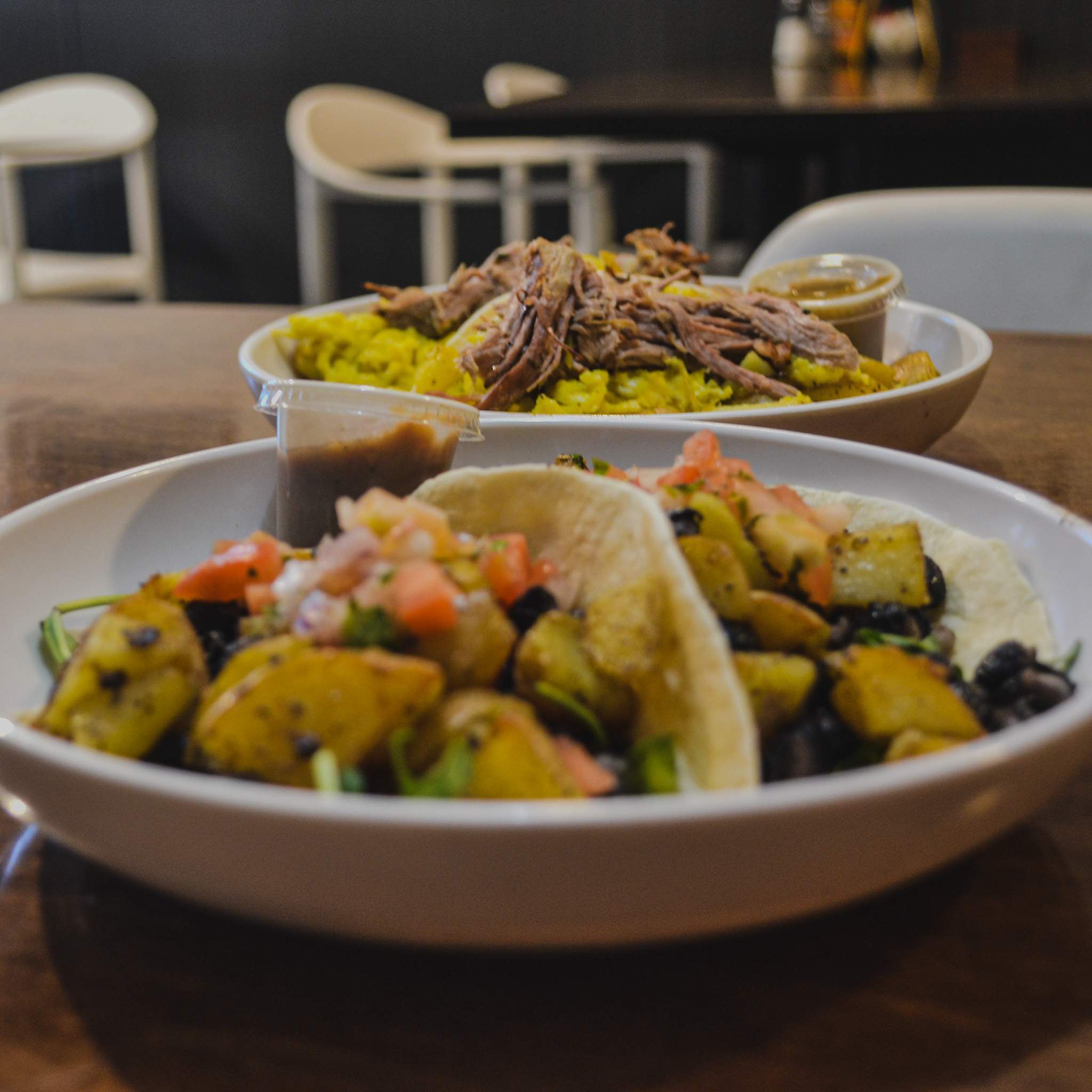 Two plated dishes photographed on a table inside The Groove restaurant.