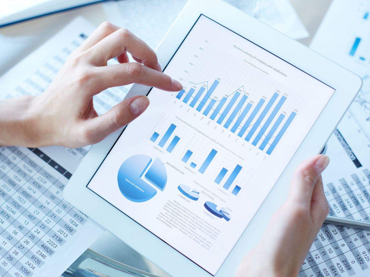 A close-up of hands holding a tablet with a clean business chart, representing the project's data-driven outcome.