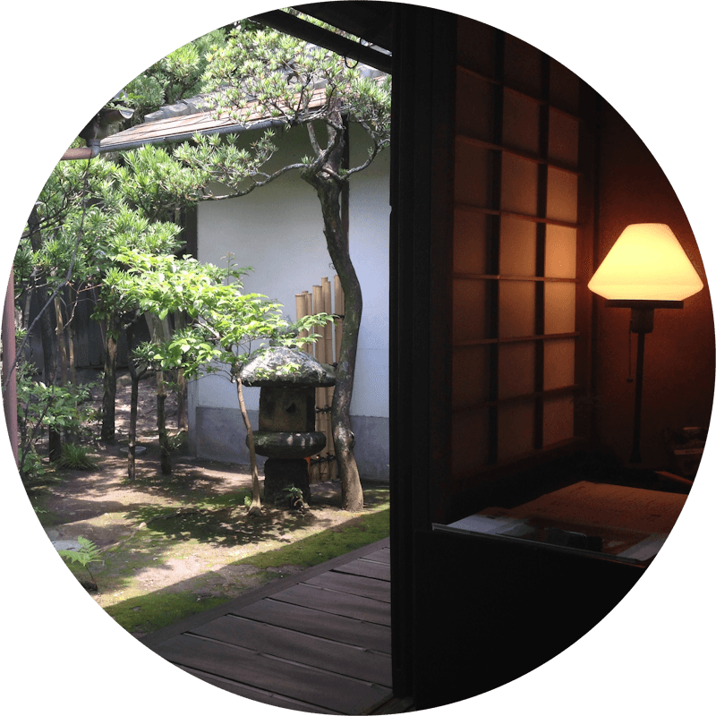 Desk and lamp in an open room overlooking a traditional Japanese garden, Kyoto, Japan.