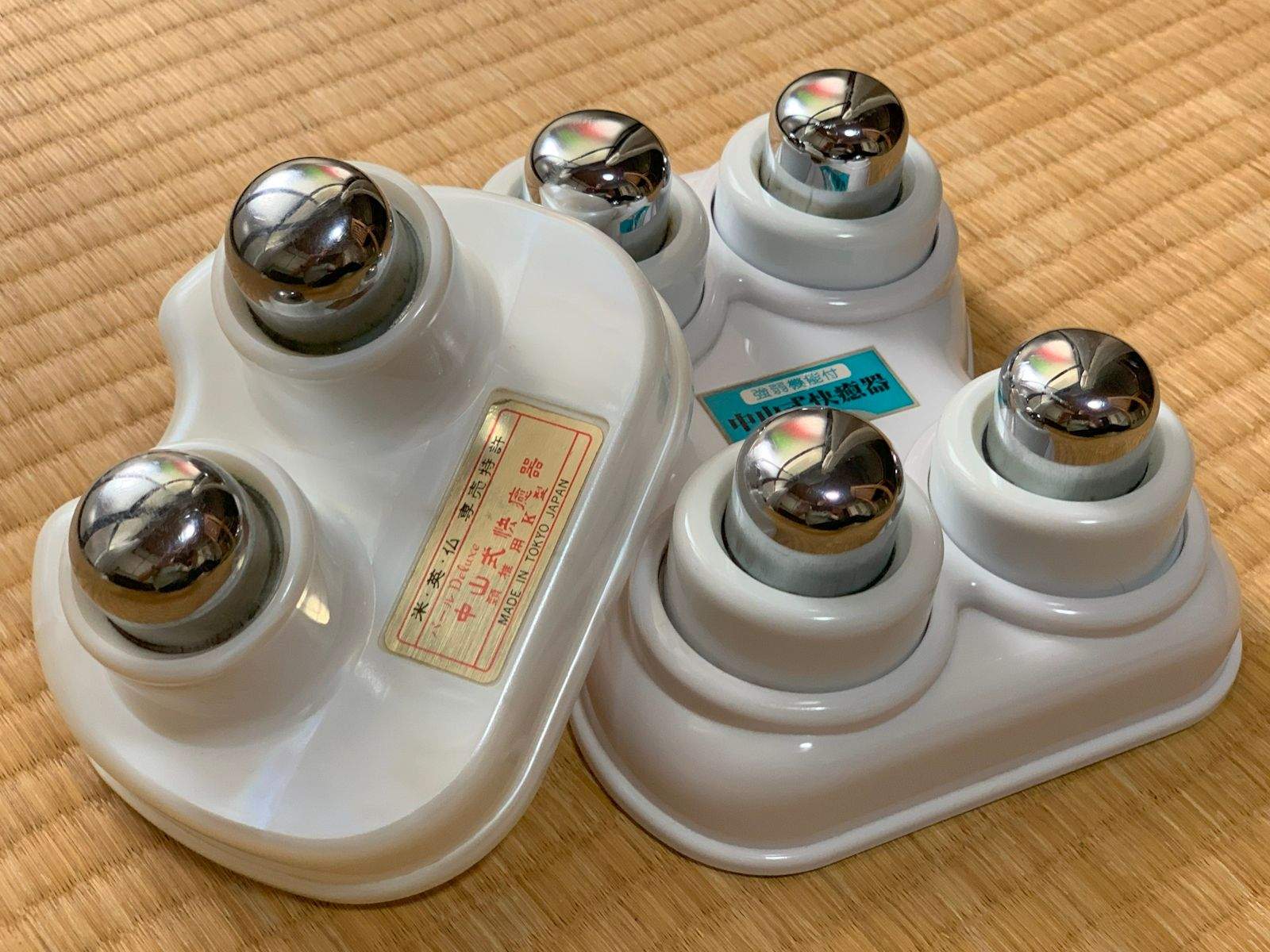 Nakayama healing devices, both 2- and 4-ball versions, sitting together on a tatami floor.