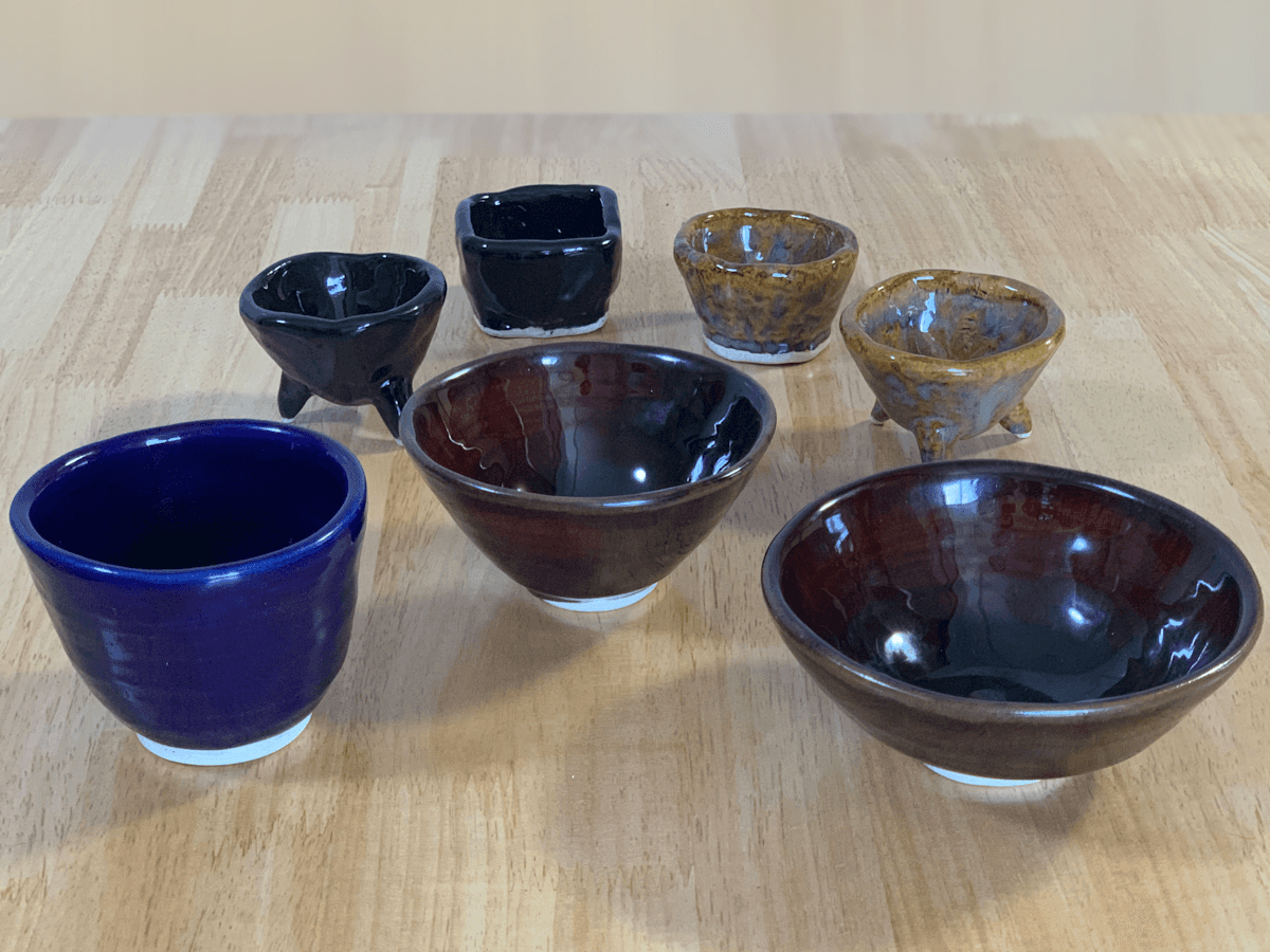 A group of handmade ceramic vessels, including a cup, bowls and small pinch pots, all made by the author.
