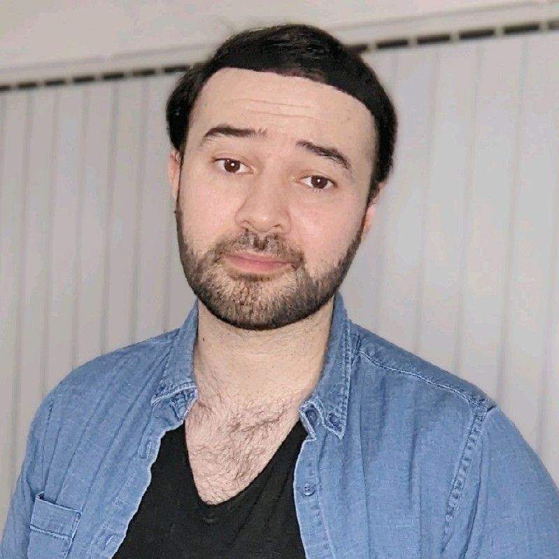 A headshot of myself wearing a blue denim shirt and a black t-shirt.