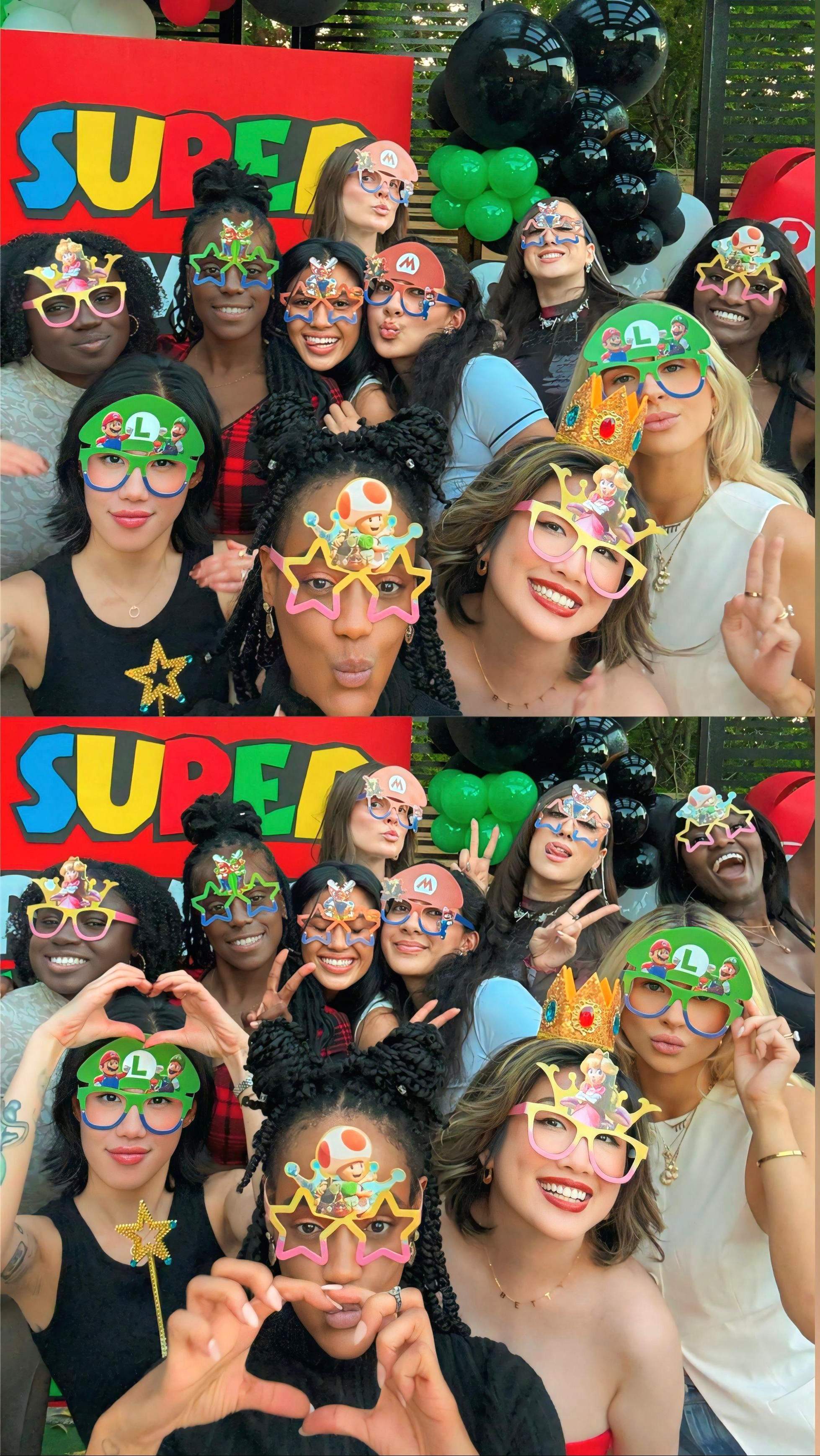  A large, diverse group of women smiling together at a Super Mario themed birthday party in front of a balloon display.