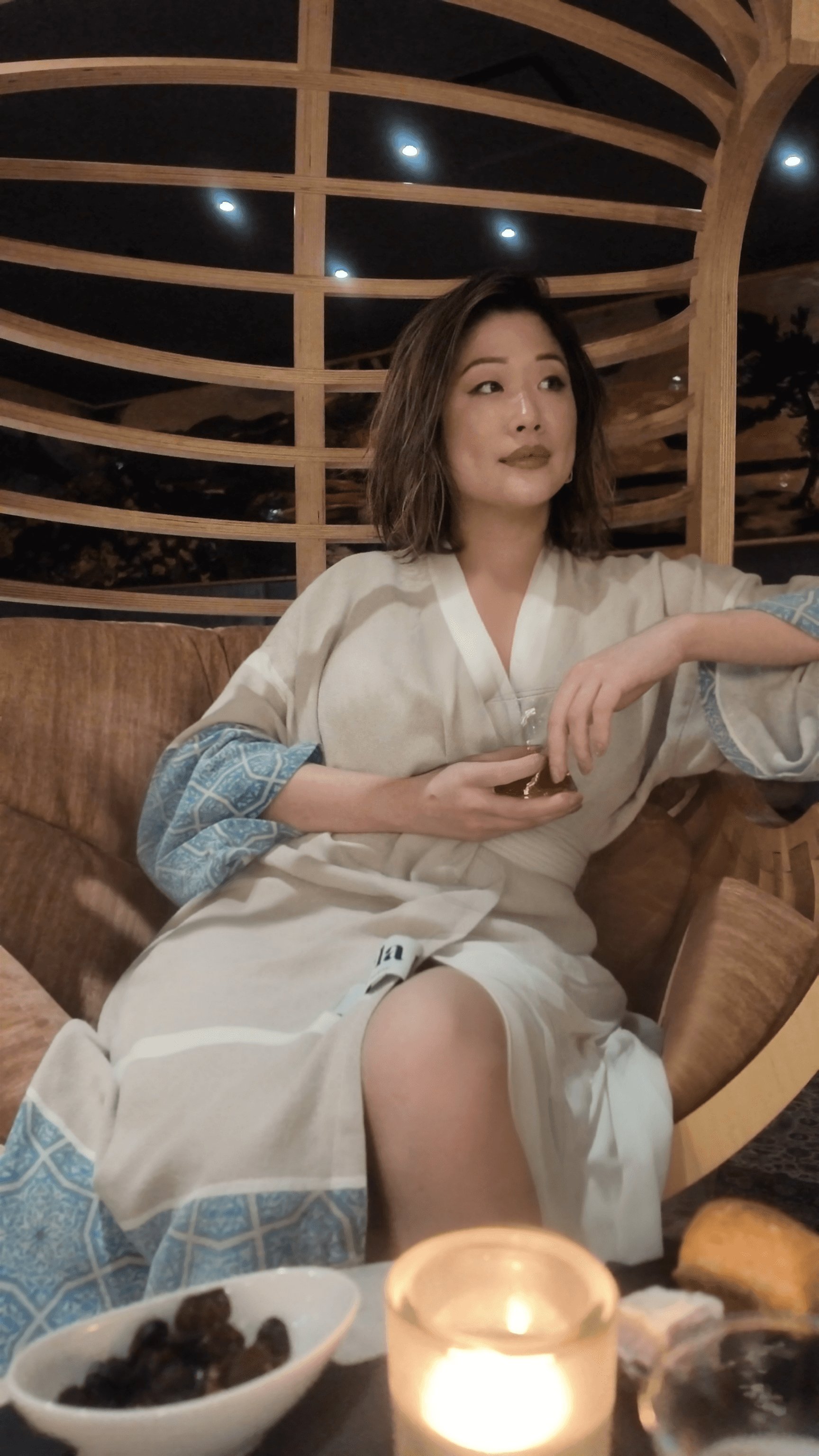Betty Lam relaxes in a sculptural chair in Hammam Spa's tea lounge, sipping tea after a luxury treatment—perfect urban sanctuary.