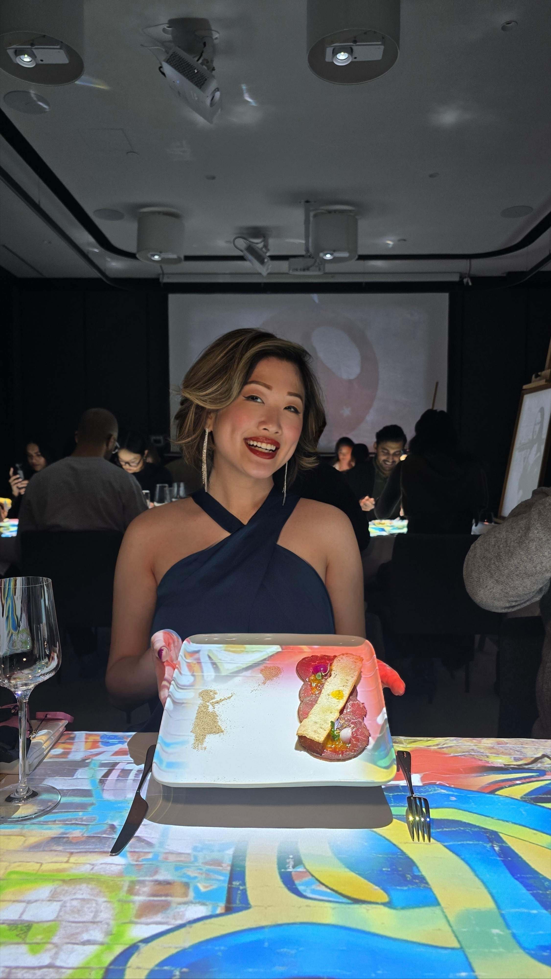 A guest holds the Banksy-inspired beef carpaccio dish at 7 Paintings Toronto's immersive art dinner.