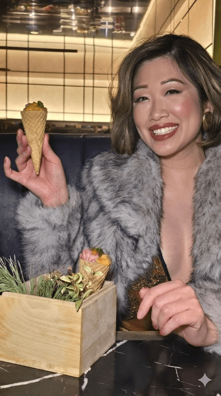 Betty Lam holding a luxury handroll filled with Uni, Ikura, and Bluefin Tuna. Part of the limited-time Holiday Tasting Menu at Flame Sushi T
