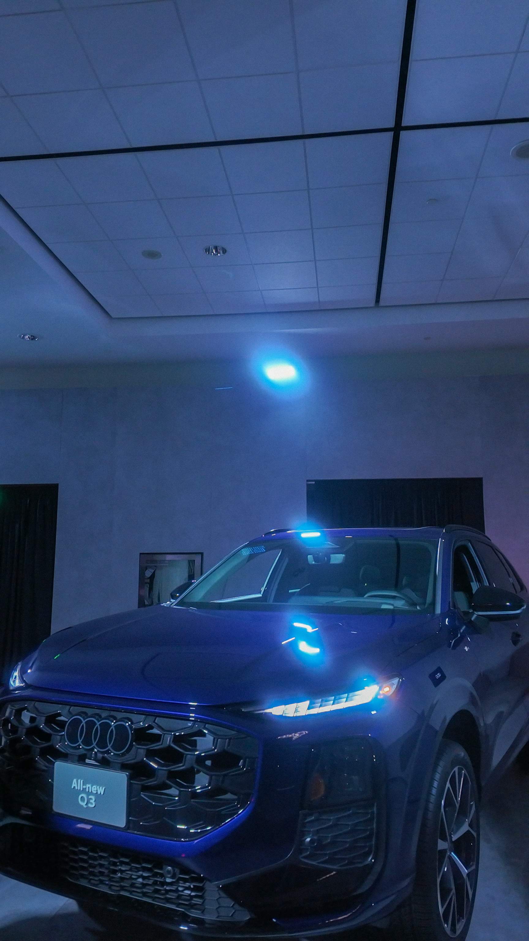 all-new dark blue Audi Q3 SUV, showcasing its advanced glowing Digital Matrix LED headlights 