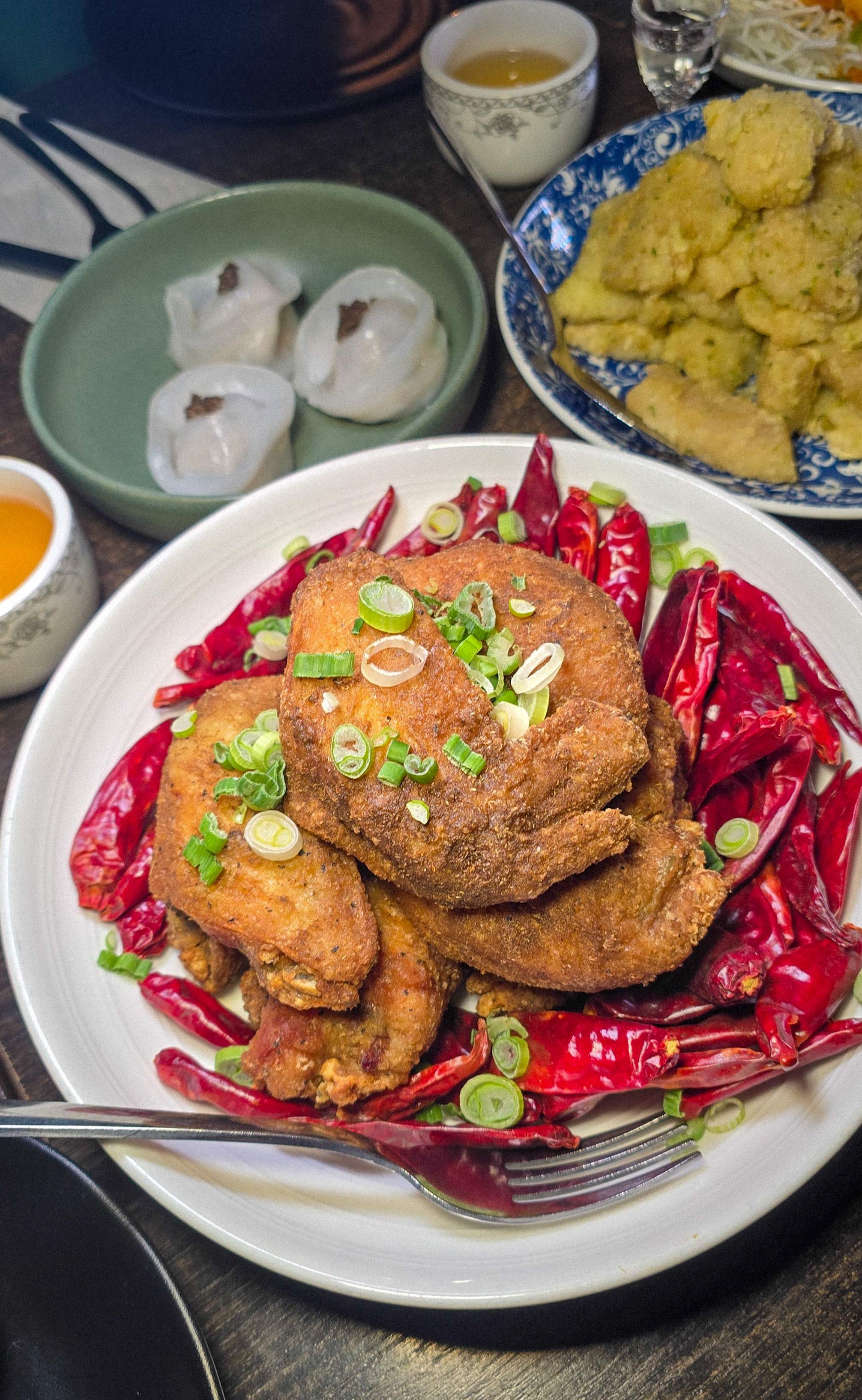 Flat lay of Halal Chinese food at Hong Shing Toronto featuring spicy shrimp, ginger scallion cod, crystal dumplings, and Mala wings.