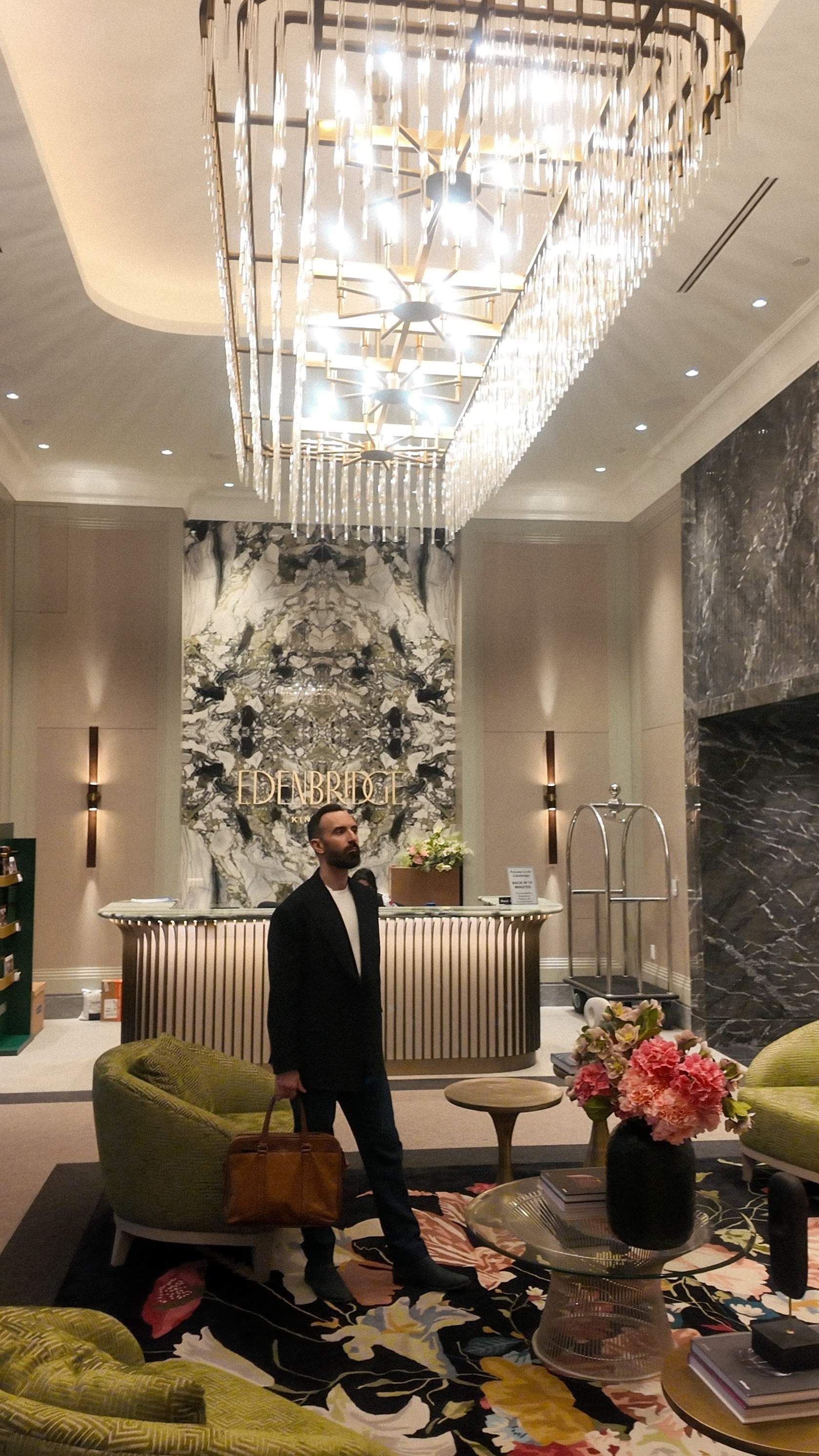 The lobby at Edenbridge by Tridel features bookmatched marble and a modern chandelier, defining elevated luxury living in Toronto.