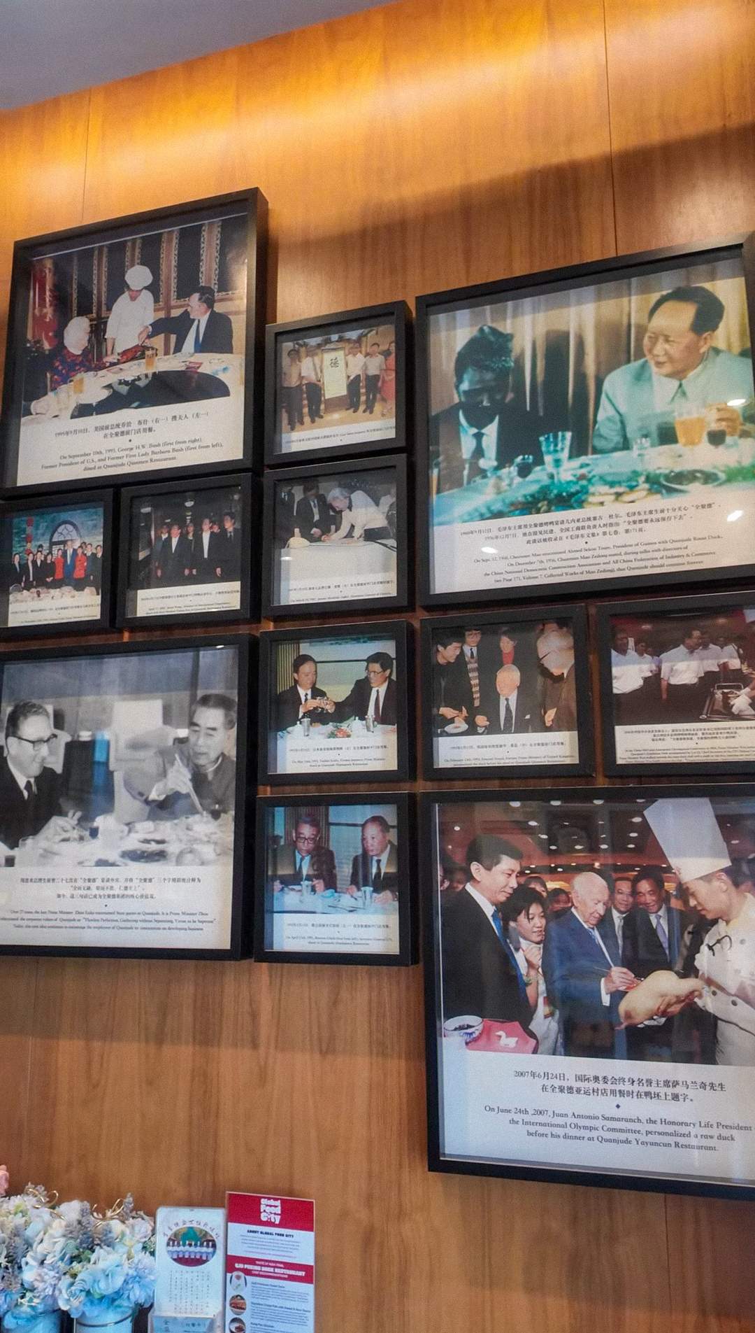 Wall of framed historical photos at QJD Peking Duck Markham showing Quanjude restaurant dignitaries and world leaders including George H.W. 