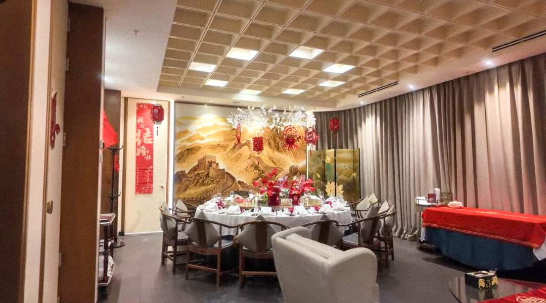 Elegant large banquet room at QJD Peking Duck Markham with stunning Great Wall of China mural feature wall round dining table set for a cele
