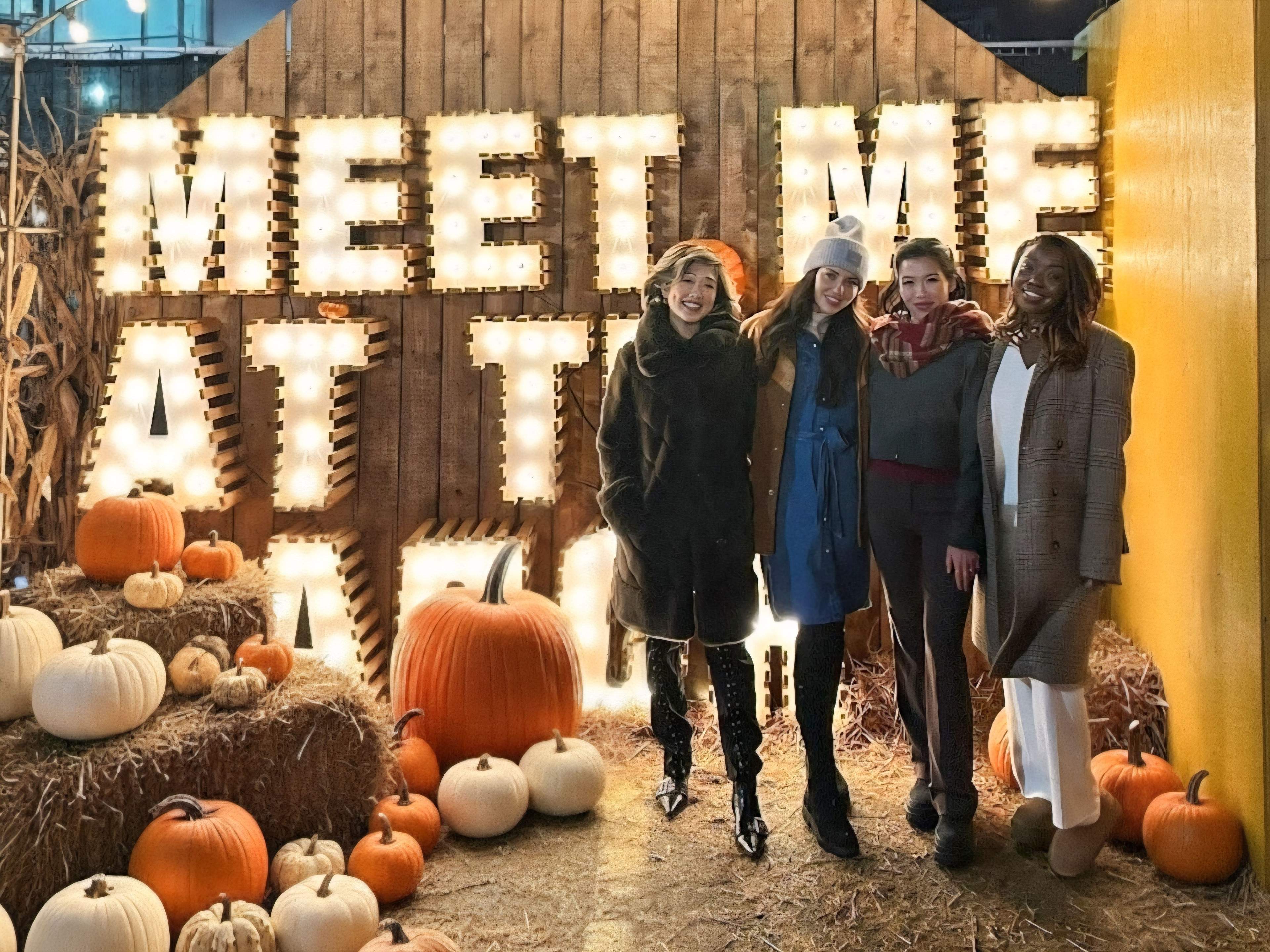 Betty Lam with @glamfriends.to at Nights of Lights "Meet Me At The Patch" sign. Group photo at Toronto fall festival with marquee lights.
