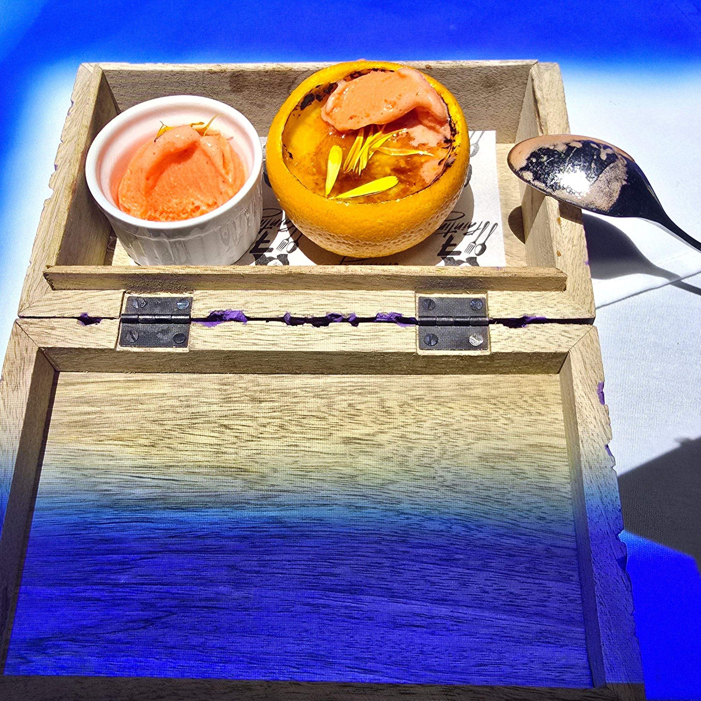 The Dalí-inspired Orange Crème Brûlée dessert course in a box at 7 Paintings, an immersive dining show in Toronto