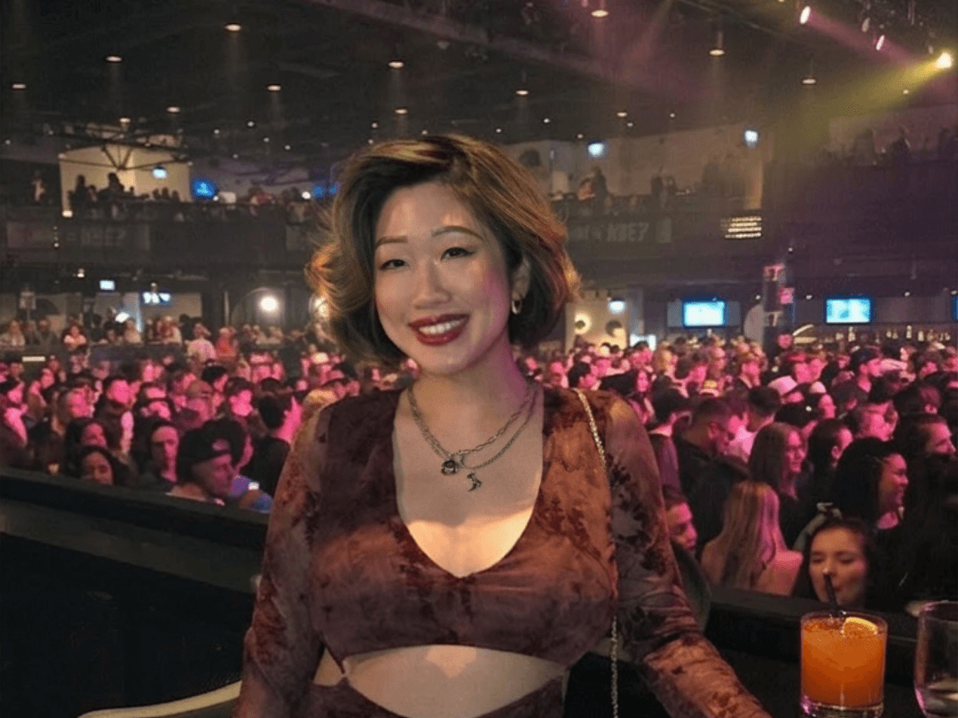 Smiling in the VIP North Floor Box at HISTORY Toronto in a fun country glam dress for the BET99 Bailey Zimmerman concert experience!