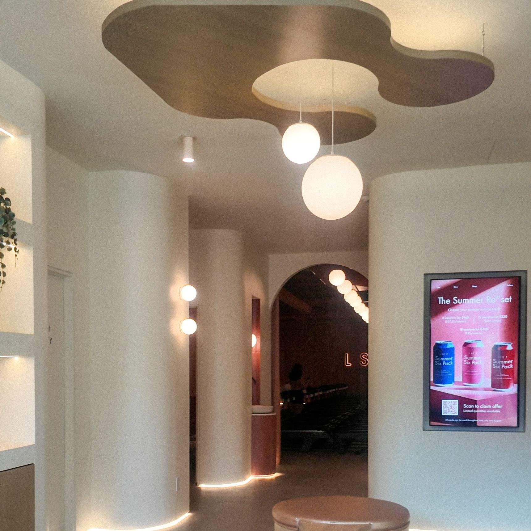 LSD°R Summerhill Toronto lobby with organic sculptural ceiling cloud ottomans globe lights and archway leading to reformer studio