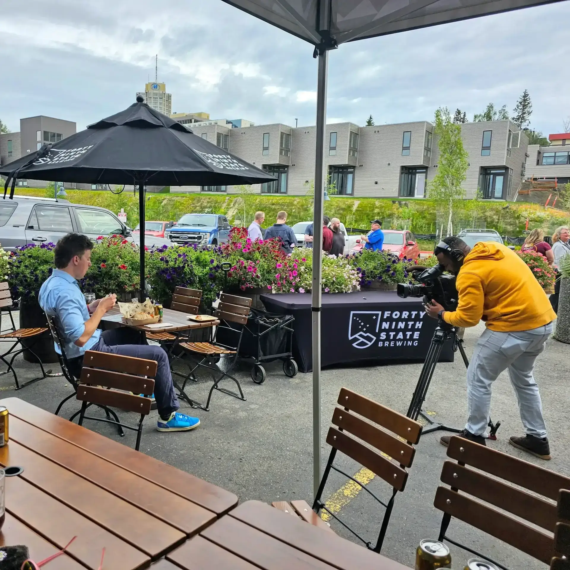 A KTUU reporter recording a segment from 49th State Brewing at The Rail, following the opening event.