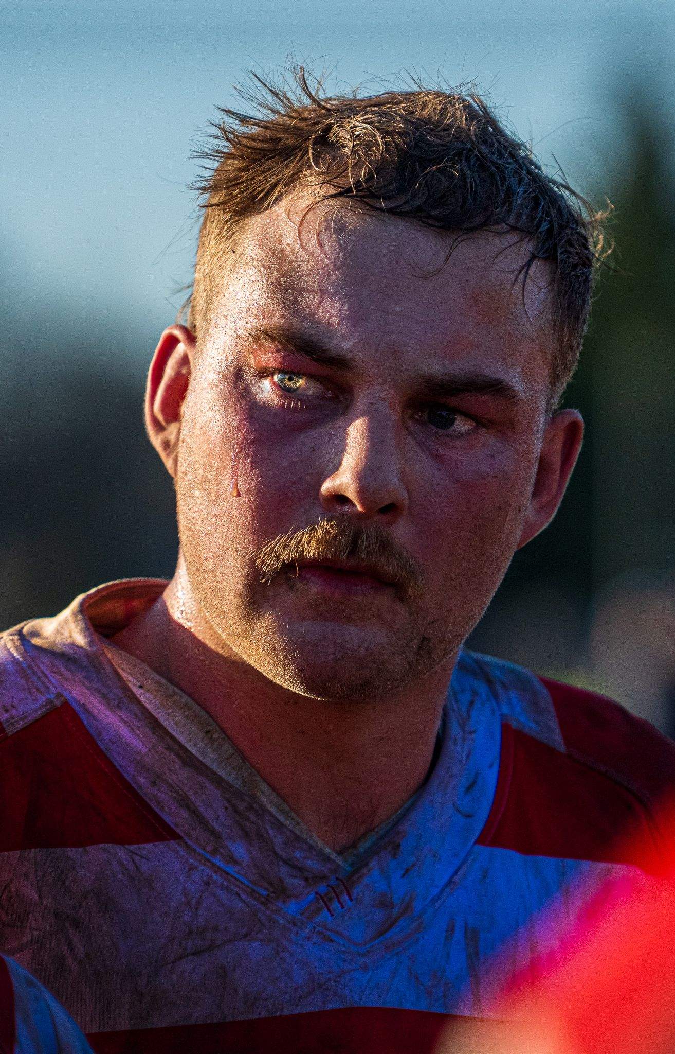 Close up rugby photo taken of rugby player in Christchurch New Zealand. full of raw emotion, tear coming out of eye, capture by Cam Furley.
