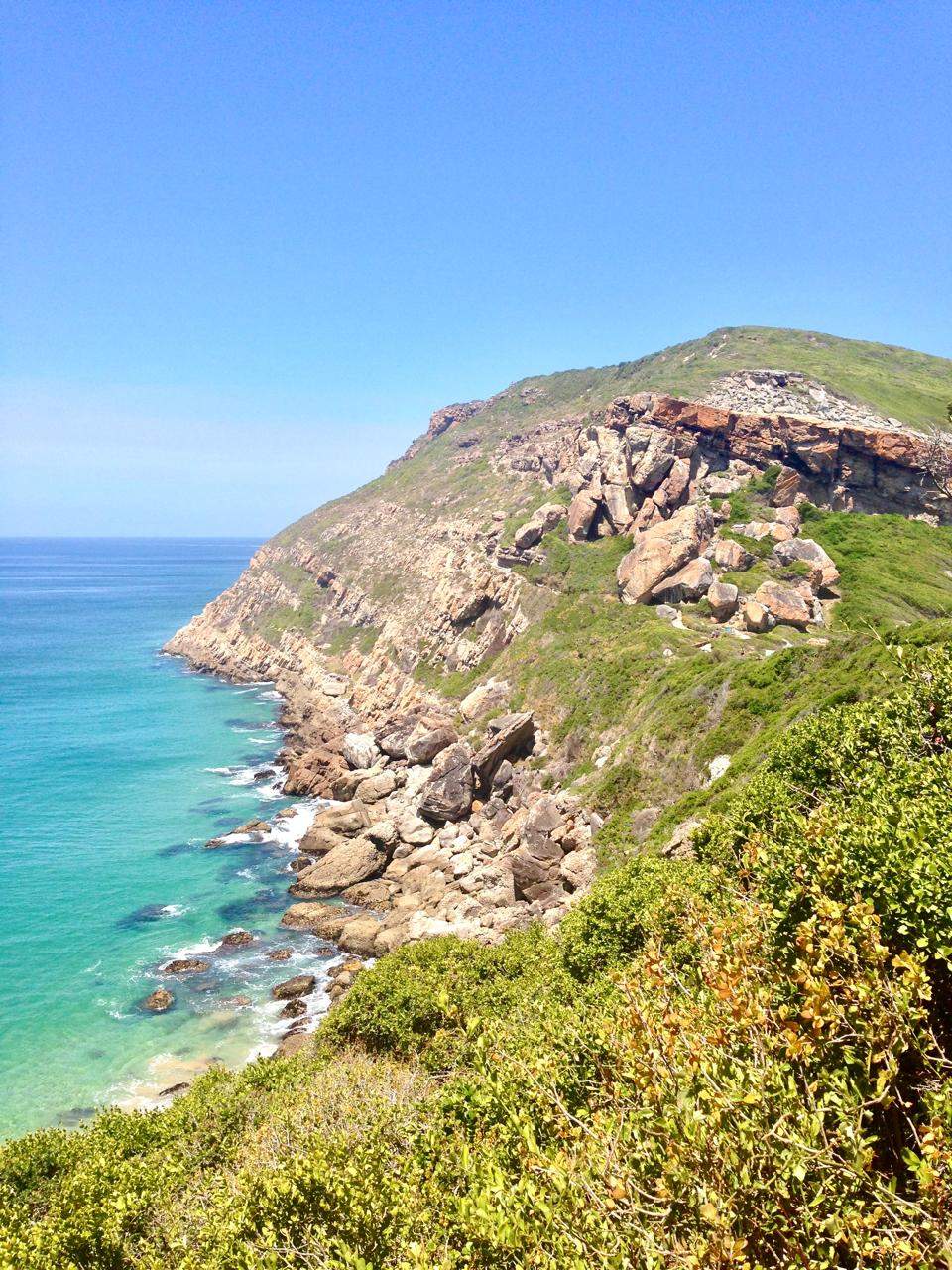 Rocky coastline and cliffs at Robberg Nature Reserve, with turquoise ocean below.